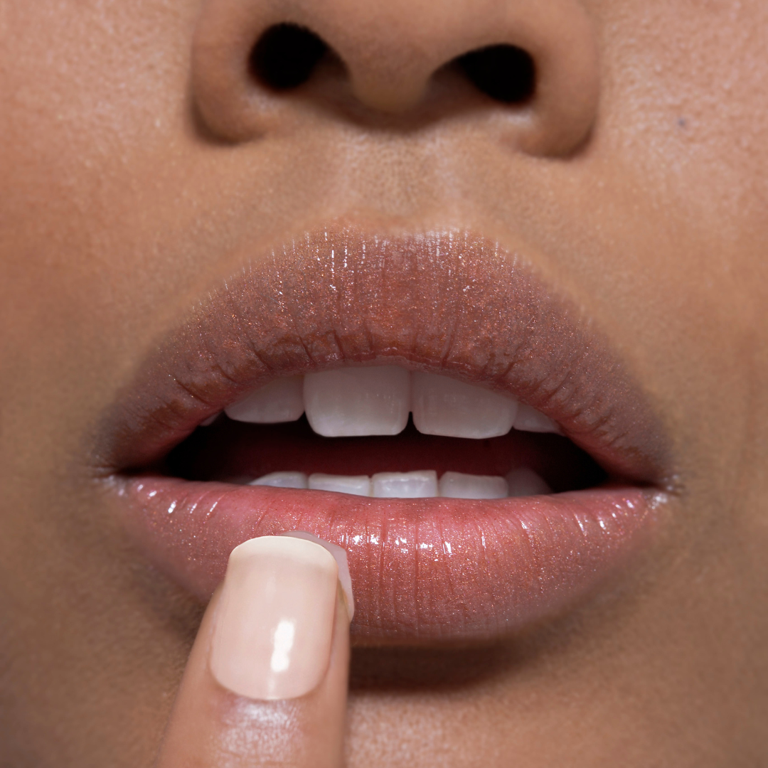 Close-up of a person's lips with a finger touching the tallow lip balm