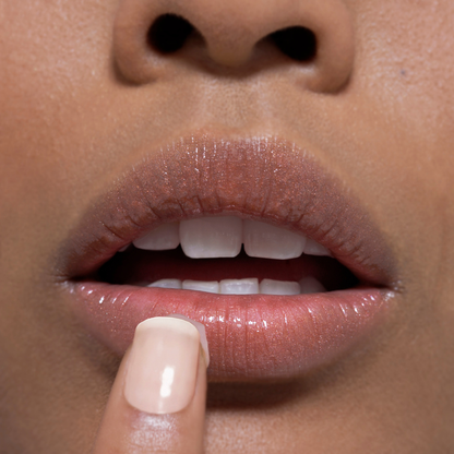 Close-up of a person's lips with a finger touching the tallow lip balm