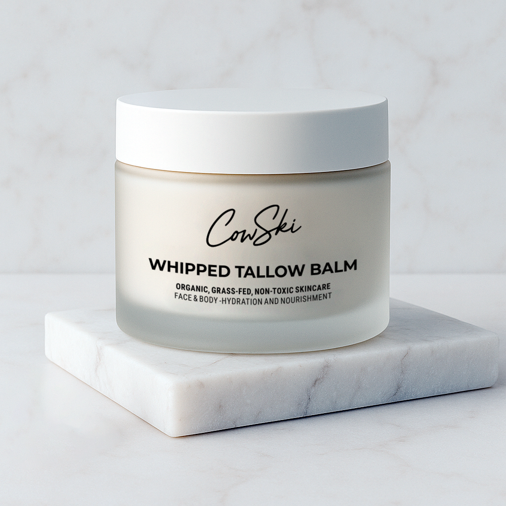 Jar of Cowski Whipped Tallow Balm on a marble surface with a light gray background